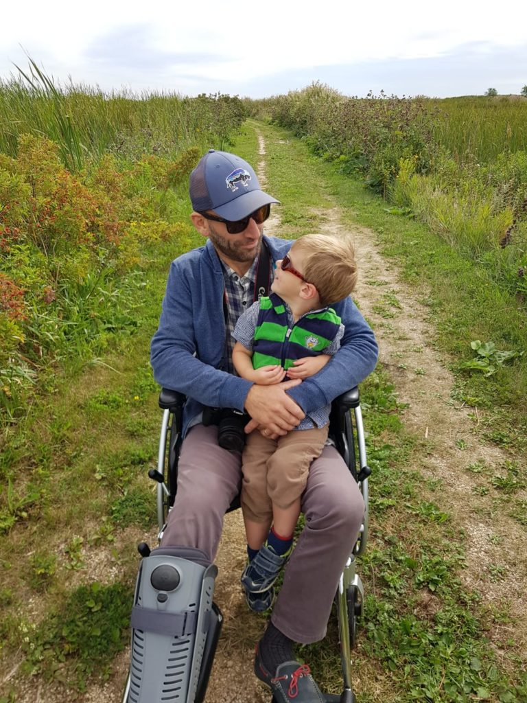 Christopher Greenfield in a wheelchair with son, Oscar.