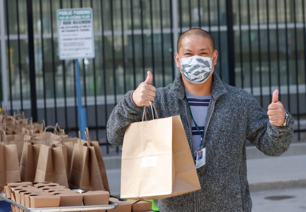 HSC Nurse carrying pre-made meals for front-line staff.