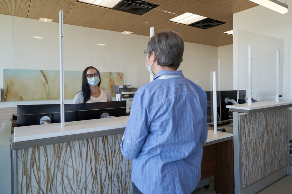 A patient speaking to a receptionist at the front desk of HSC's Transplant Wellness Centre